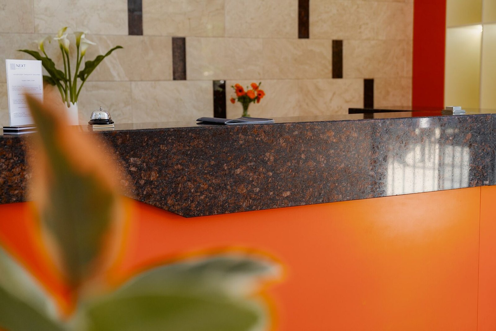 The orange reception desk and stone finishes at NEXT Orange